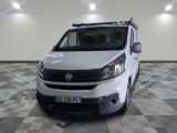 une camionnette blanche garée dans une pièce au sol en damier