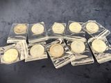 six gold coins in clear plastic bags sitting on a black surface