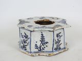 un petit vase bleu et blanc posé sur une surface blanche