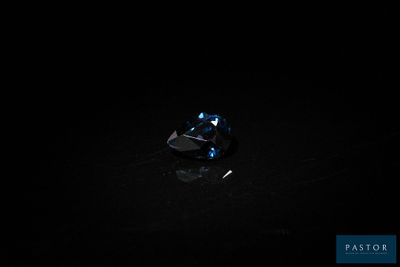 gros plan d'un diamant bleu sur une surface noire