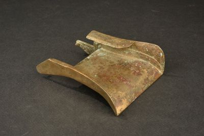 an old metal object on a black surface with a black background