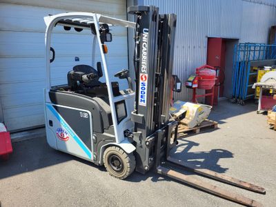 une photo d'un chariot élévateur garé devant un garage