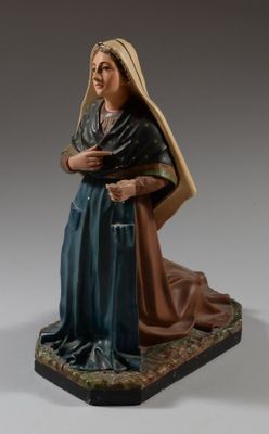 figurine représentant une femme en robe bleue, assise sur un tapis
