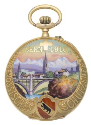 une image représentant une montre de poche en or sur laquelle figure l'image d'une ville