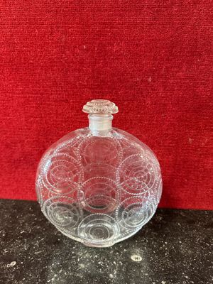 an image of a glass bottle on a table with a red background