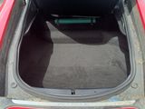 a red car with its trunk open in a parking lot