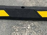une barrière en plastique jaune et noire posée au sol dans un parking