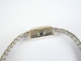 a silver bracelet with a silver clasp on a white surface