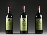 three bottles of wine are lined up on a table