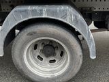 a white truck with a flat tire parked on the street