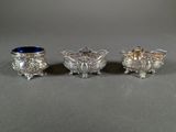 three silver and blue glass vases sitting on top of a table