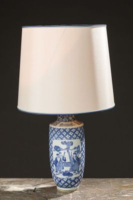 a blue and white table lamp with a white shade on it