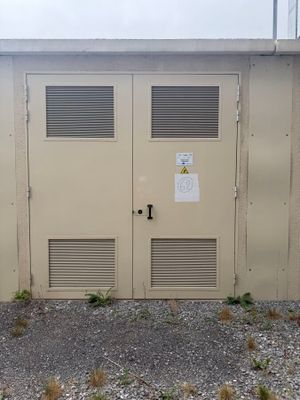 deux portes situées sur le côté d'un immeuble sur lequel est accrochée une enseigne