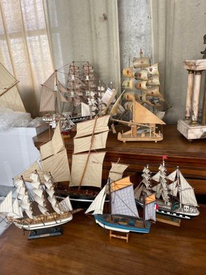 de nombreuses maquettes de bateaux posées sur une table dans une pièce