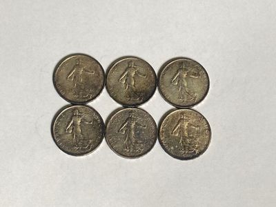 a close up of six coins on a white surface