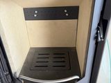 a black stove with a door open on a tiled floor