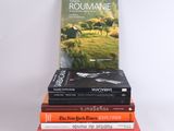 several books stacked on top of each other on a white surface