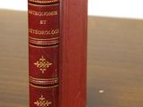 un livre rouge posé sur une table en bois