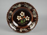assiette marron et blanche ornée de fleurs sur un fond gris