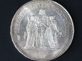 a silver coin with a picture of a woman and two men on it