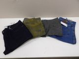 five pairs of men ' s jeans sitting on a white table
