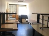 une salle équipée de bureaux et de chaises