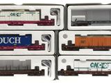 six wagons de train miniature se trouvent dans une boîte posée sur une surface blanche
