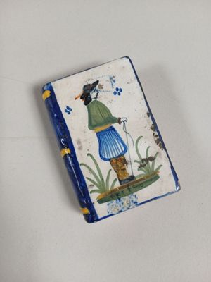 un petit livre sur lequel figure la photo d'un homme