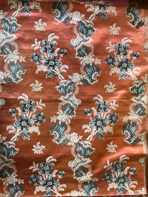 an orange and blue floral print fabric with a white and blue flower pattern