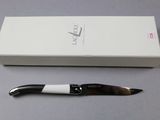 a black and white knife sitting next to a white box