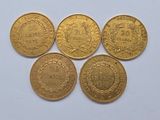 four gold coins with the names of different countries on them