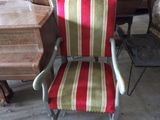 a red and green striped chair in the middle of a room