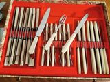 many knives and knives in a red tray on a table