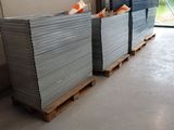 de nombreuses piles de tôles empilées sur des palettes dans un entrepôt