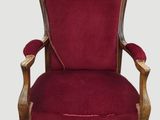 une chaise rouge avec une structure en bois et un revêtement en velours rouge