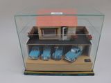 une vitrine contenant trois voitures devant une maison