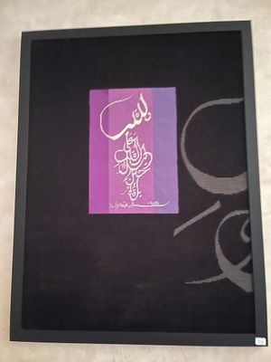 peinture représentant une calligraphie arabe sur un cadre noir, avec un fond violet et pourpre