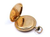 an image of a gold pocket watch sitting on a white surface