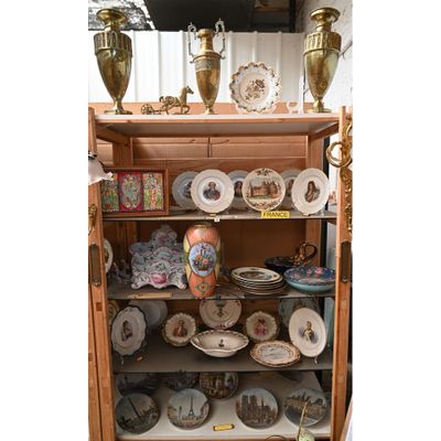 de nombreuses assiettes et vases posés sur une étagère dans un meuble