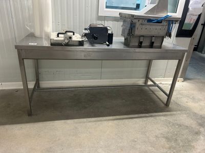 une table sur laquelle est posée une machine, dans une pièce