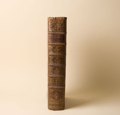 un vieux livre posé sur une table à côté d'un mur