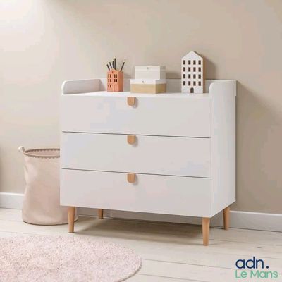 a white dresser with three drawers in a room