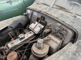 an old car with a broken engine in the back of it