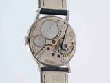 a close up of a watch on a white surface with a white background