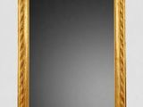 a gold framed mirror sitting on top of a white wall