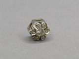 a close up of a silver bead with a flower design on it