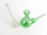 deux vases en verre vert posés l'un à côté de l'autre sur une surface blanche