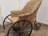 un fauteuil à bascule à l'ancienne, avec une assise rembourrée à motifs floraux et des roulettes