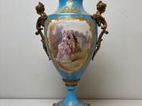 un vase bleu avec une peinture dessus, posé sur une table
