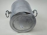 a metal container with a handle on a white surface